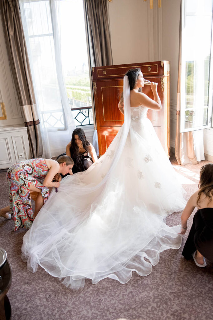 bride drinking champagne while getting ready for her wedding in Paris