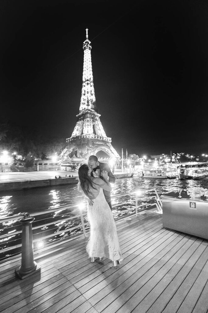 bride and groom kissing at night in Paris in front of the Eiffel Tower